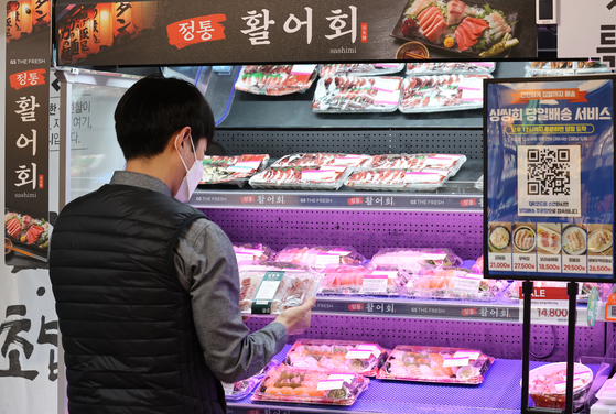 A customer picks up a hoe (raw fish) dish at a GS The Fresh store in Gangnam, southern Seoul, on Monday. The supermarket brand operated by GS Retail launched a same-day delivery service of fresh hoe on Monday. Orders made before 12 p.m. will be delivered by 8 p.m. on the same day in a number of cities, including Seoul, Incheon, Suwon, Gwacheon and Goyang. [YONHAP]