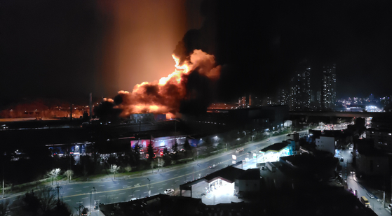 Flames and smoke shoot up in the air in Daejeon Sunday evening as a fire broke out at a Hankook Tire factory. [YONHAP]
