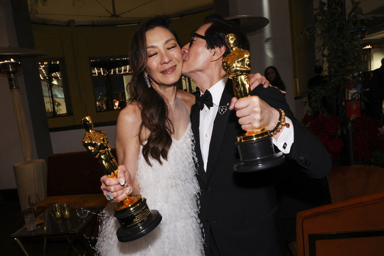 Best Supporting Actor Ke Huy Quan and Best Actress Michelle Yeoh pose with their awards at the Governors Ball following the Oscars show at the 95th Academy Awards in Hollywood, Los Angeles, California, U.S., Sunday local time. [REUTERS]