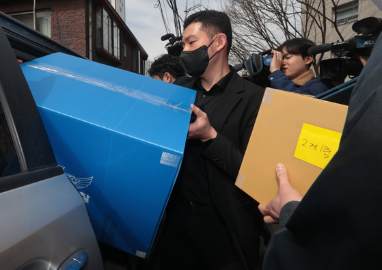Police investigators load materials seized from a raid on the northern Seoul headquarters of the Korean Construction Workers' Union into a vehicle on Tuesday. [YONHAP]