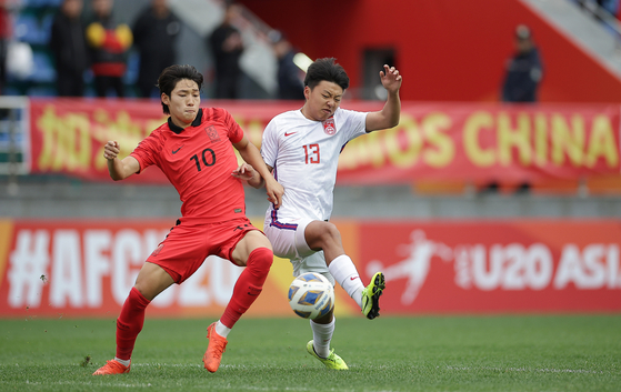 Bae Jun-ho, left, vies for the ball with Gao Yunan during a quarterfinal match between Korea and China at the AFC U-20 Asian Cup in Tashkent, Uzbekistan on Sunday. [XINHUA/YONHAP]