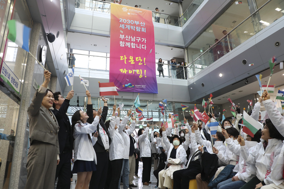 Residents of Nam District, Busan celebrate the start of a volunteer group that will promote the city's bid to host the World Expo in 2030 at the district office Tuesday. Busan is competing against Riyadh, Rome and Odesa. The host city will be announced in November at the Bureau International des Expositions headquarters in Paris. [YONHAP]