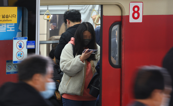 Commuters wear masks on a Seoul subway train on Tuesday. [YONHAP]
