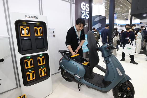 A KooRoo employee demonstrates its Battery Swapping Station that allows EV drivers to simply exchange batteries instead of charging them when they are exhausted. [YONHAP] 