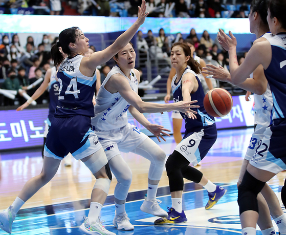 Asan Woori Bank Woori Won's Go A-ra, second from left, passes the ball during the second leg of the playoffs against the Incheon Shinhan Bank S-Birds at Incheon Dowon Gymnasium in Incheon on Monday. [NEWS1] 