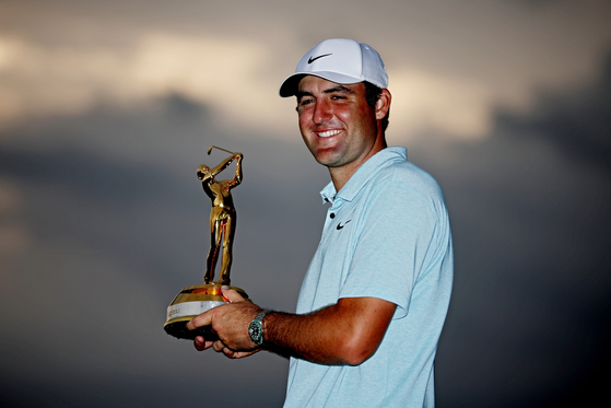 Scottie Scheffler poses with the tournament trophy after winning The Players Championship at Stadium Course at TPC Sawgrass on Sunday in Ponte Vedra Beach, Florida. [GETTY IMAGES]