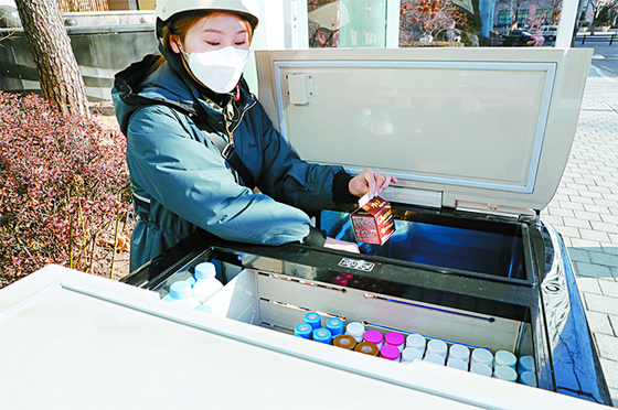 A young Fresh Manager, the job title for sellers of the Korean Yakurt products, arranges dairy goods on her mobile refrigerated cart. [HY]