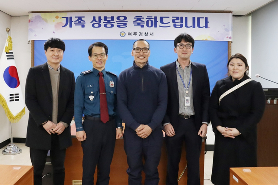 An adoptee who lost his Korean birth family 42 years ago at a bus terminal, center, pose with officials from the police and National Center for the Rights of the Child on Thursday at Yeoju Police Precinct in Yeoju, Gyeonggi, after reuniting with his biological mother and older brother. [KOREAN NATIONAL POLICE AGENCY]