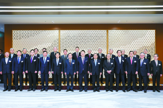 President Yoon Suk Yeol, front row center, poses for a photo with business leaders from Korea and Japan at a business roundtable in Tokyo on Friday. [JOINT PRESS CORPS]