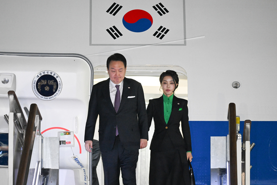 President Yoon Suk Yeol, left, and Korean first lady Kim Keon-hee return from a two-day trip to Tokyo on Air Force One at Seongnam Air Base in Gyeonggi Friday evening. [JOINT PRESS CORPS]