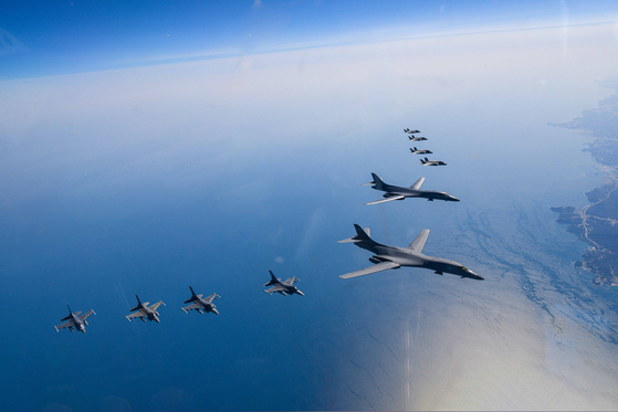 Two U.S. B-1B strategic bombers fly in the center of a formation alongside South Korean F-35A stealth fighters (above) and U.S. F-16 fighters (below) during a joint air force drill in tge skies above the Korean Peninsula on Sunday after the North launched a suspected short-range ballistic missile. [DEFENSE MINISTRY] 