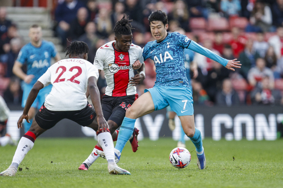 Tottenham's Son Heung-min, right, and Southampton's Romeo Lavia, center, compete for the ball during a Premier League match at St Mary's Stadium in Southampton, England on Saturday.  [AP/YONHAP]