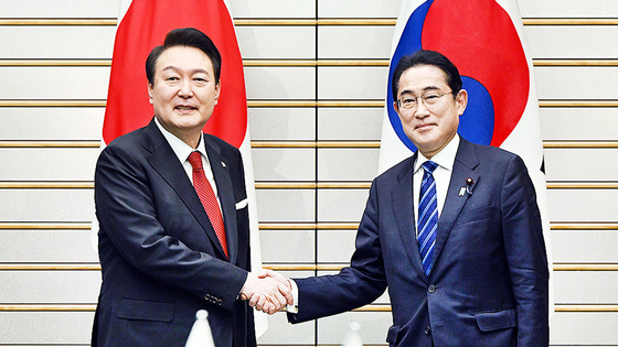 Korean President Yoon Suk Yeol, left, and Japanese Prime Minister Fumio Kishida shake hands during their summit at the prime minister's residence in Tokyo Thursday. [JOINT PRESS CORPS] 