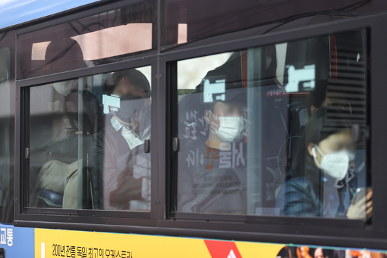 The mask mandate on public transportation in Korea was lifted Monday for the first time in two and a half years, but many people say they aren't ready to de-mask, like the passengers on a Seoul bus shown above. [YONHAP]