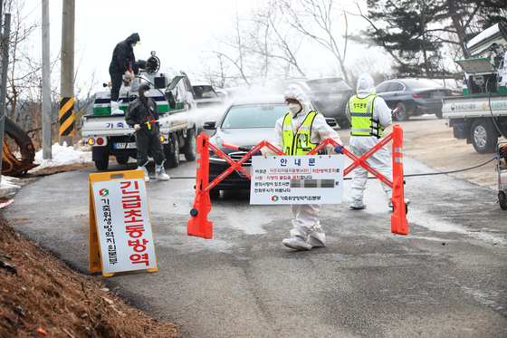Quarantine officials block a road leading to a pig farm in the county of Yangyang, Gangwon, on Feb. 12, 2023, after confirming an African swine fever case there. [YONHAP]