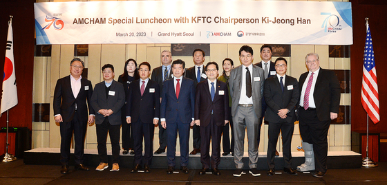 Fair Trade Commission (FTC) Chairman Han Ki-jeong, fourth from right, and American Chamber of Commerce in Korea Chairman James Kim, fourth from left, pose for a photo at a conference held to discuss the FTC’s policy direction for this year at Grand Hyatt Seoul in central Seoul on Monday. [AMCHAM]