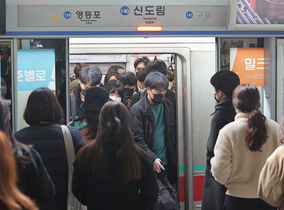 People getting on and off of a subway at the Sindorim station in Seoul on Monday. Although the mandatory mask wearing on public transportation has been lifted, many still continues to wear them. [YONHAP]