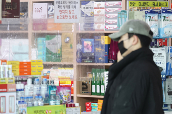 A person stands in a pharmacy in Seoul Station on Sunday, a day before the public transportation mask mandate lift. [YONHAP]