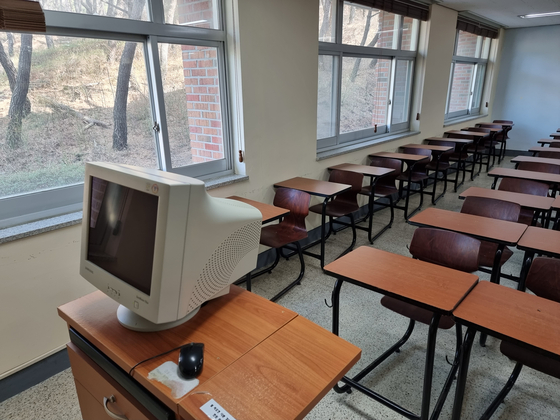 A classroom at a four-year private university in North Gyeongsang stands empty with an outdated computer visible on the professor's desk on March 6, the first Monday after the academic year began in Korea. [LEE HOO-YEON]