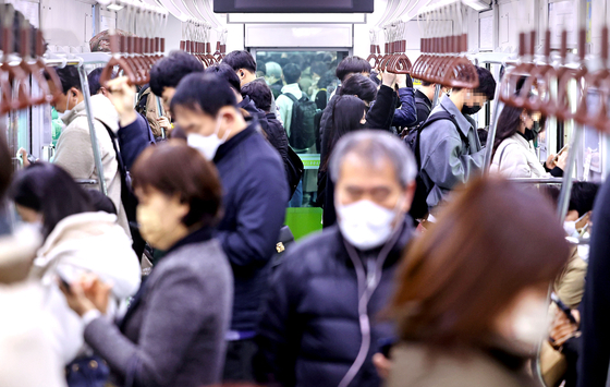 People wear masks on a subway car in Seoul on Monday morning, the first day the mask mandate on public transportation was lifted. [YONHAP]