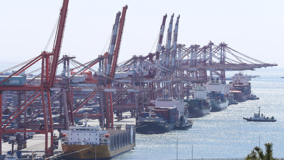 Cranes unload containers from carriers at Busan Port on March 13. [YONHAP]