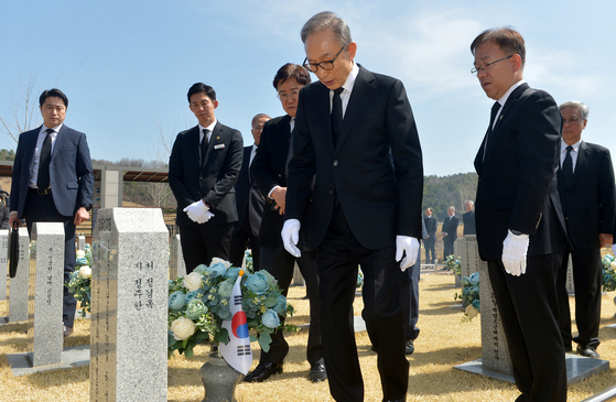 Former President Lee Myung-bak, center, pays respects at the graveyard of 46 sailors killed aboard the South Korean warship Cheonan in an attack by North Korea on March 26, 2010, at the national cemetery in Daejeon, Wednesday. The visit marks Lee's first official activity since he was released from prison on a special pardon by President Yoon Suk Yeol last December. Lee had been serving a 17-year sentence for embezzlement and bribery since November 2020. The sinking of the Cheonan happened when Lee was in office, and he pledged to visit the cemetery every year. [YONHAP]