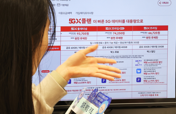 A customer looks over subscription plan choices at a SK Telecom store in Myeongdong, central Seoul, on Thursday. [YONHAP]
