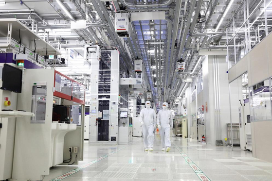 Samsung Electronics engineers walk in a production line facility in the company's chip complex in Pyeongtaek, Gyeonggi. [YONHAP]