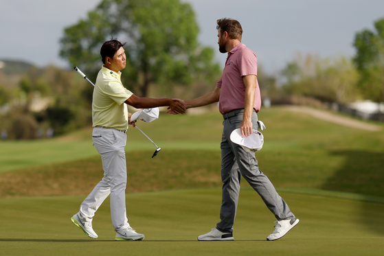 Kim Si-woo and Chris Kirk of the United States shake hands on the 15th green after Kim won their match 4 & 3 during day one of the World Golf Championships-Dell Technologies Match Play at Austin Country Club on Wednesday in Austin, Texas. [GETTY IMAGES]