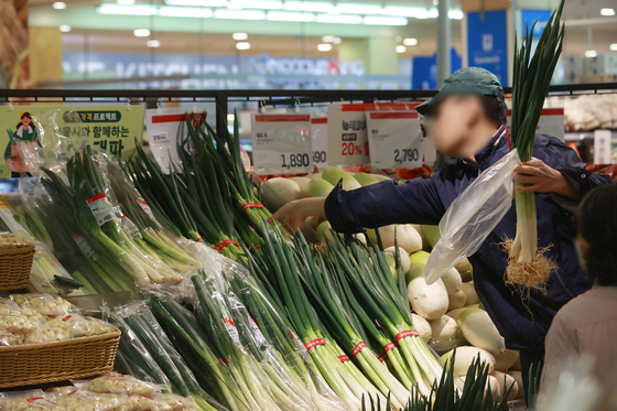 A customer picks up a leek bundle at a discount shop in central Seoul on Thursday. The city government of Seoul will supply 20 tons of leek at a 38 percent discount from Thursday to March 29 as part of its project to bring affordable groceries to residents. [YONHAP]