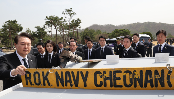 President Yoon Suk Yeol views a nameplate commemorating the sailors killed in the sinking of the Cheonan ship in 2010 at Daejeon National Cemetery in Daejeon on Friday to mark the eighth West Sea Defense Day. [JOINT PRESS CORPS]