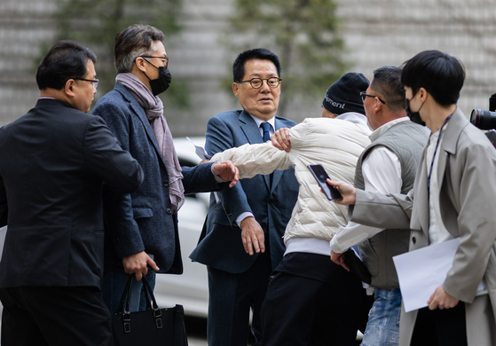 Former head of the National Intelligence Service Park Jie-won, center, lunged by Lee Rae-jin, the brother of the fisheries ministry employee, who was killed by North Koreans in 2020, in front of the Seoul Central District Court in Seoul on Friday. The trial against Park for conspiring against the deceased public servant started on the same day that commemorates those that died defending the Yellow Sea in numerous provocation by North Koreans. [YONHAP]