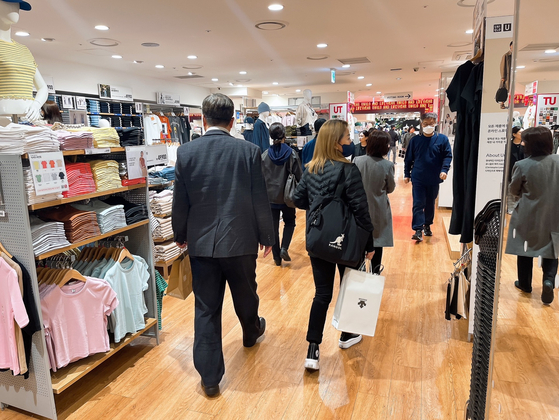 People shop at a Uniqlo store in Seoul on March 15. [SOHN DONG-JOO]