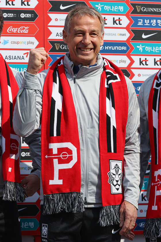 Korean national team manager Jurgen Klinsmann poses in a Korean national team scarf designed by Over the Pitch.  [YONHAP]