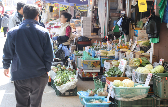 A pedestrian walks past a vegetable stand at a traditional marketplace in Seoul, Sunday. The potato price is forecast to stay strong through April at between 70,000 won ($53.9) and 75,000 won per 20 kilograms, which is 4 to 12 percent more expensive compared to the previous year, according to the Korea Rural Economic Institute Sunday. [YONHAP]