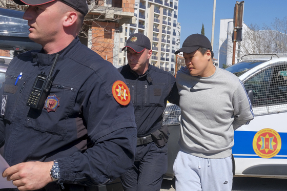 Terraform Labs founder Do Kwon, right, is escorted by Montenegrin police officers in Podgorica on Friday, [AP/YONHAP]