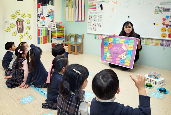 A grammar class is held at Edible Village, where kids learn the difference between past, present and future tense through games with foreign teachers. [PARK SANG-MOON]