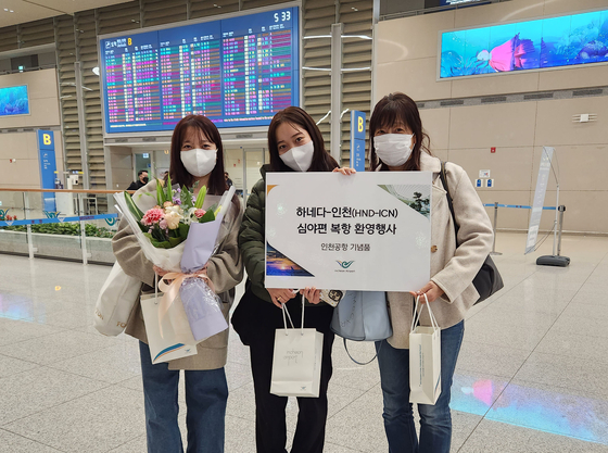 Japanese travelers pose for a commemorative photo at Incheon International Airport on Monday morning. [YONHAP]