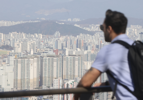 A person looks at the city of Seoul from Mount Namsan on Sunday. [YONHAP]