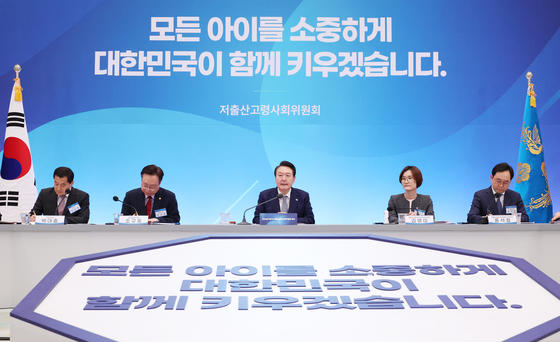 President Yoon Suk Yeol, center, addresses Korea’s low birth rate problem at the first meeting of the Presidential Committee on Ageing Society and Population Policy at the Blue House in central Seoul on Tuesday afternoon. [JOINT PRESS CORPS]