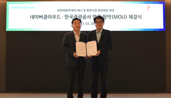  Naver Cloud’s executive director Kim Tae-chang, left, and Yoo Jin-ho, the head of travel package department of Korea Tourism Organization, pose for the photo after signing a memorandum of understanding in Gangnam District, southern Seoul, on Tuesday. [NAVER CLOUD]