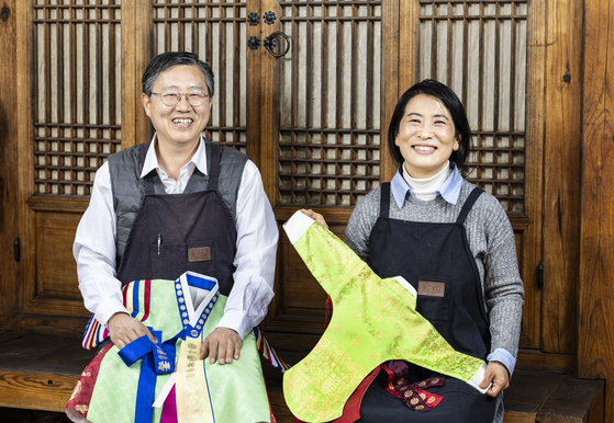 Kim Ki-ho, left, and Park Soo-young, right, both geumbakjang artisans, pose for a photo at their studio in Jongno District, central Seoul, on March 17. [KIM HYUN-DONG]