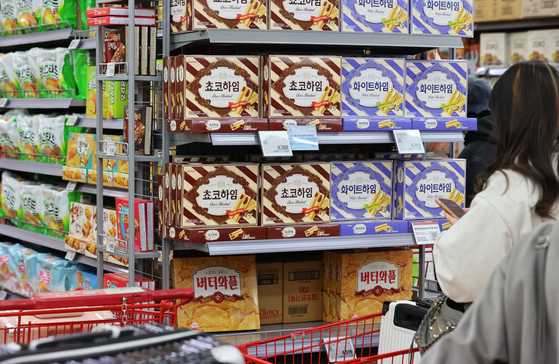 A customer stands in front of a snack isle at a discount store in Seoul on Monday. [YONHAP]