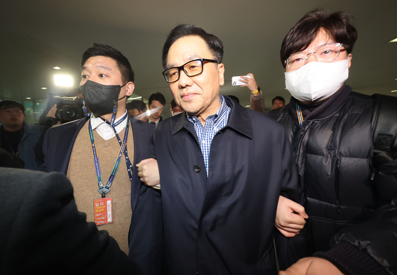 Prosecution officials arrest Cho Hyun-chun, center, a former head of the now-defunct Defense Security Command, at Incheon International Airport on Wednesday. [YONHAP]