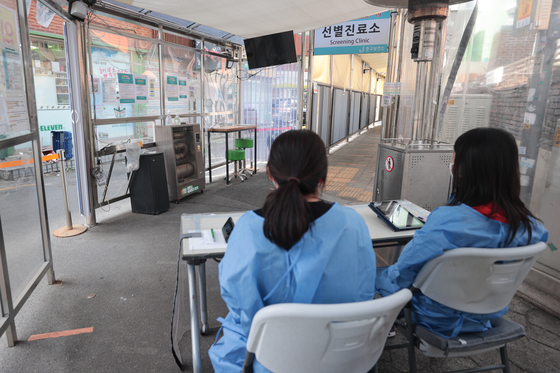 Health officials sit at an empty government-run Covid-19 screening clinic in Jung District, central Seoul, on Wednesday. [YONHAP]