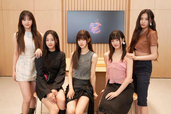 Girl group NewJeans pose for photos before an interview with the local press on March 29 at the newly-opening Apple Gangnam retail store in southern Seoul. [APPLE KOREA]