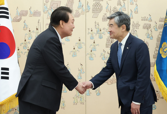 President Yoon Suk Yeol, left, shakes hands with Cho Tae-yong, his new national security adviser, in an appointment ceremony at the Yongsan presidential office in central Seoul Thursday. [JOINT PRESS CORPS]