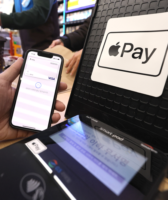 An employee demonstrates Apple Pay at a convenience store in Gangnam, southern Seoul, on March 21. [NEWS1]