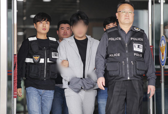 The 32-year-old eldest son of former Gyeonggi Gov. Nam Kyung-pil, center, leaves a police station in Yongin, Gyeonggi, Saturday. A Suwon court later issued an arrest warrant for Nam, who is accused of taking methamphetamine. [NEWS1]