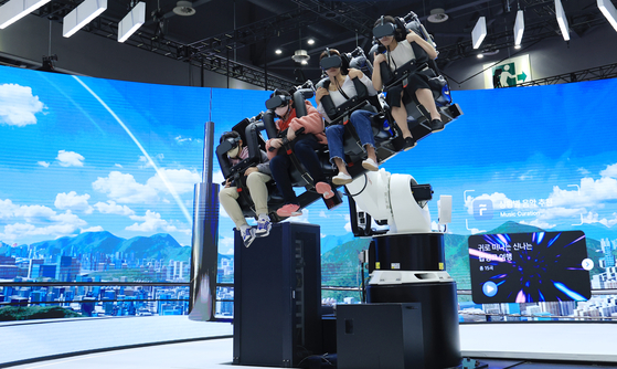 Visitors take a ride on an urban mobility vehicle (UAM) simulator at SK Telecom's booth at the 2023 Seoul Mobility Show at Kintex in Gyeonggi on Sunday. The mobility show runs through April 9. [YONHAP] 